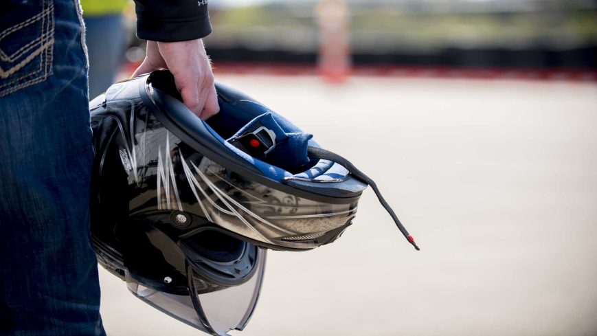 Un homme qui tient son casque de moto