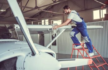 Nettoyage d'un avion avec une lingette par un homme